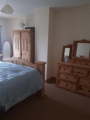a bedroom with a bed and a dresser and a mirror at NO 9 The Willows, Ballinamore, Entire home in Ballinamore