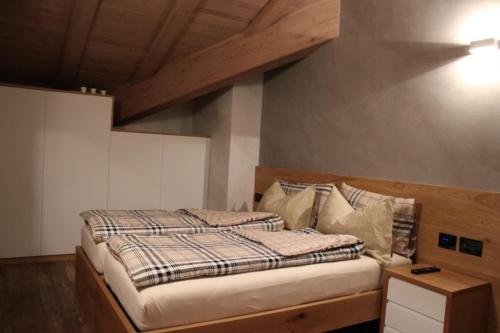 a bedroom with a bed with a wooden headboard at Appartamento Suite centro Livigno 4S - Sabrina in Livigno
