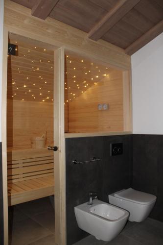 a bathroom with a toilet and a tub with lights at Appartamento Suite centro Livigno 4S - Sabrina in Livigno