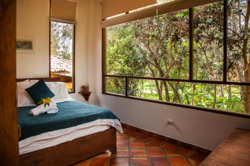 a bedroom with a bed and a large window at Clavellino House en Villa de Leyva - Tranquilidad y Naturaleza en Reserva Natural Urbana! in Villa de Leyva