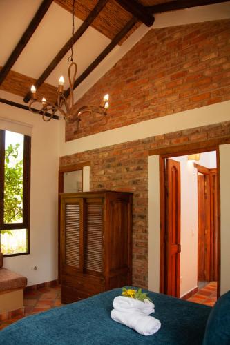 a room with a blue bed with towels on it at Clavellino House en Villa de Leyva - Tranquilidad y Naturaleza en Reserva Natural Urbana! in Villa de Leyva
