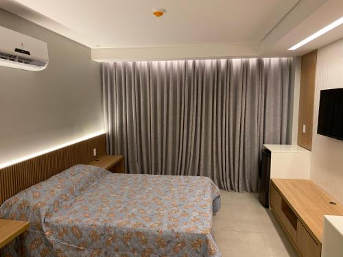 a hotel room with a bed and a television at RESORT PRAIA DOS CARNEIROS in Tamandaré