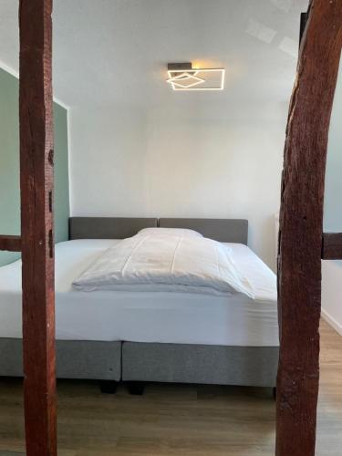 a bedroom with a bed with white sheets at Hotel Jägerhof in Coesfeld