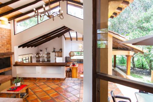 an open kitchen and living room with a vaulted ceiling at Clavellino House en Villa de Leyva - Tranquilidad y Naturaleza en Reserva Natural Urbana! in Villa de Leyva