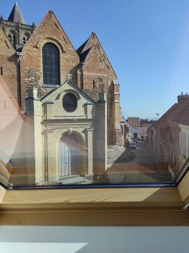 an open book with a picture of a church at Gîte Au Cœur de Cassel in Cassel