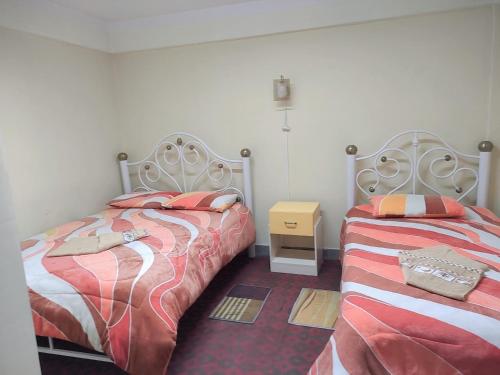 dos camas sentadas una al lado de la otra en un dormitorio en Hostal La Realeza, en Potosí