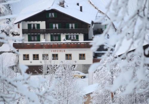 a building covered in snow with snow covered trees at Hotel-Pension Faneskla in Silbertal
