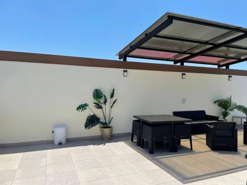 a patio with a table and chairs and a roof at Bejuco Beachfront Condo FRENTE A LA PLAYA hermoso condominio NUEVO in Esterillos Este