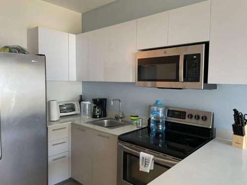 a small kitchen with a sink and a microwave at Bejuco Beachfront Condo FRENTE A LA PLAYA hermoso condominio NUEVO in Esterillos Este