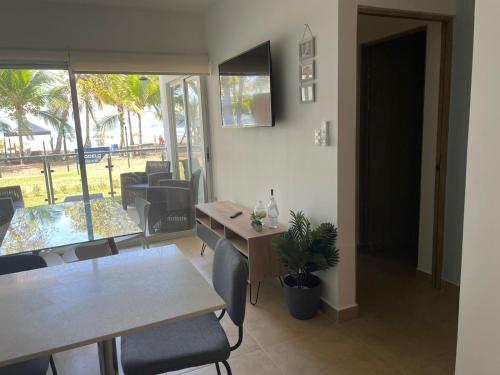 a dining room with a table and chairs and a window at Bejuco Beachfront Condo FRENTE A LA PLAYA hermoso condominio NUEVO in Esterillos Este