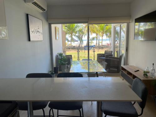 a dining room with a table and chairs and a view of the ocean at Bejuco Beachfront Condo FRENTE A LA PLAYA hermoso condominio NUEVO in Esterillos Este