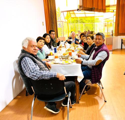 a group of people sitting around a table eating at Hotel Plaza San Antonio Arequipa in Arequipa