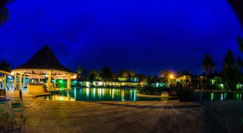 a swimming pool with a gazebo at night at Starfish Tobago in Scarborough