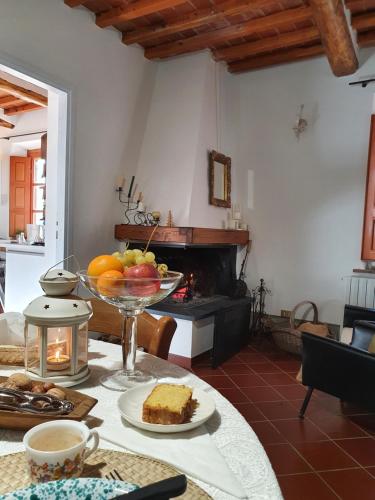 ein Wohnzimmer mit einem Tisch und einer Obstschale in der Unterkunft Pietra d'Acqua B&B in the woods in Buti