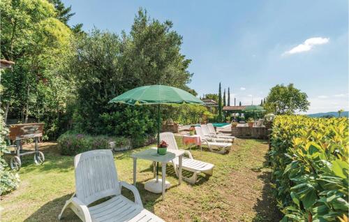 a group of chairs and an umbrella in a yard at Paucca 2 in San Valentino di Villa