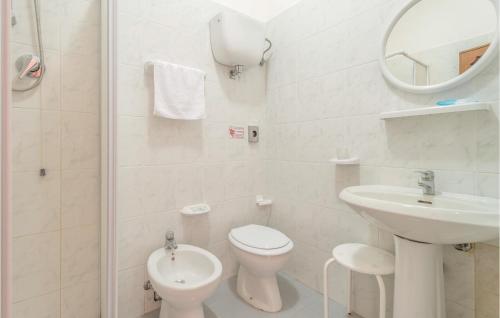 a white bathroom with a toilet and a sink at Paucca 2 in San Valentino di Villa