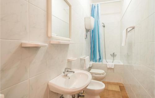 a white bathroom with a sink and a toilet at Paucca 2 in San Valentino di Villa