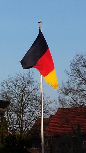 a flag on a pole in front of a house at Edemissener Gästezimmer in Peine