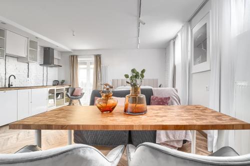 a kitchen and a table with two vases on it at Apartamenty MUNN 1 Szczecin in Szczecin