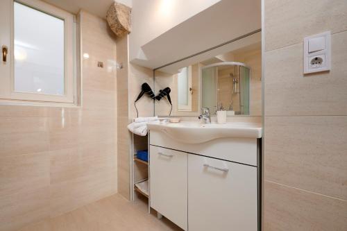 a bathroom with a sink and a mirror at Palace Central Square in Trogir