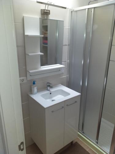 a white bathroom with a sink and a shower at La graciosa in Costa Del Silencio