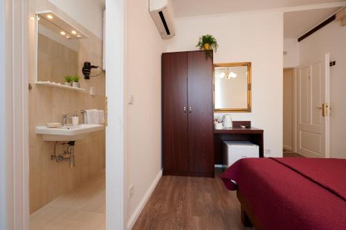 a bathroom with a sink and a bed and a mirror at Palace Central Square in Trogir