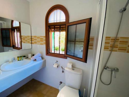 een badkamer met een toilet, een wastafel en een spiegel bij Bungalow Parque Golf by SunHousesCanarias in Maspalomas