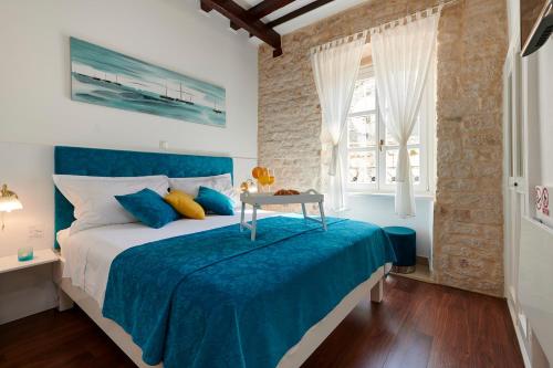 Schlafzimmer mit einem Bett mit blauer Bettwäsche und einem Tisch in der Unterkunft Palace Central Square in Trogir