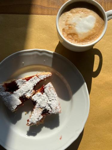 a plate with a piece of cake and a cup of coffee at LOCANDA PODERE LE VIGNE in Radda in Chianti