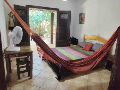 琵琶的住宿－Casa Cajueiro em Pipa，一张位于带一张床铺和一张桌子的房间的吊床