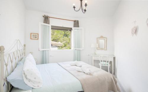 um quarto branco com uma cama e uma janela em Cosy Home with Pool ideal for Family & Sports near Beach in Port de Pollença em Pollença