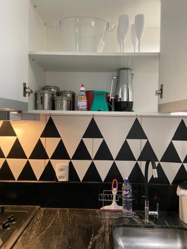 a kitchen with black and white tiles on the counter at Sinta-se em Casa! Ap Novo, Aconchegante e Funcional- Ótima localização in Montes Claros