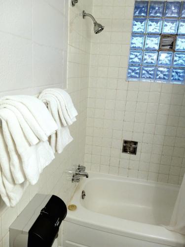 a bathroom with a white tub and white towels at Chalet Inn Motel in Dryden