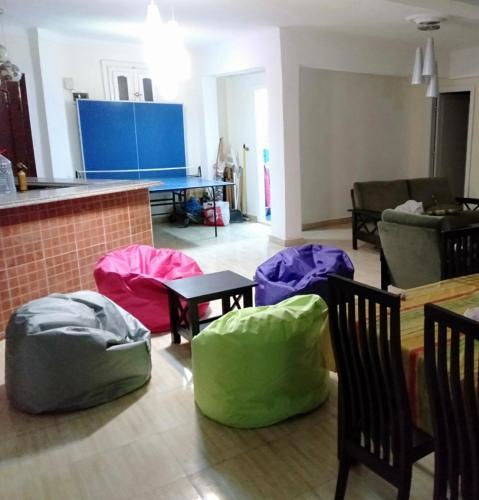 a living room with chairs and colorful bags on the floor at شالية 180م بالروف 180م قرية هليوبيتش الساحل الشمالي للايجار للعائلات فقط in Dawwār ‘Abd al Qādir Qāsim