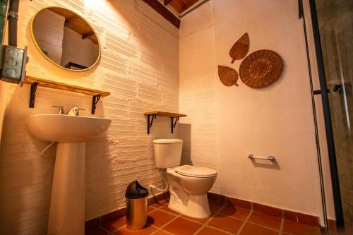 a bathroom with a toilet and a sink and a mirror at Centro Hostel Medellin in Medellín