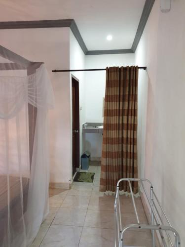 a room with a shower curtain and a chair at Five Time Homestay in Gili Islands
