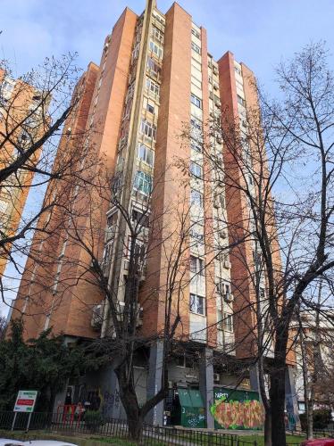a tall brick building with trees in front of it at PentLux - SPA Penthouse in the heart of Skopje in Skopje