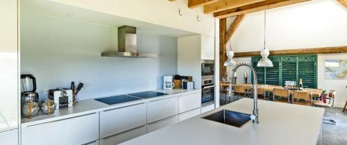a kitchen with white counters and stainless steel appliances at TopLocatiezeeland # Sea Barn in Oostkapelle