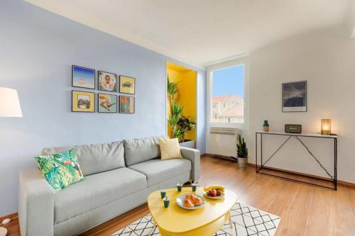 een woonkamer met een bank en een tafel bij Splendide appartement sur le cours Estienne d'Orves in Marseille