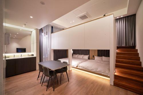 a bedroom with a bed and a table and chairs at Space and Mood in Busan