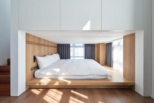 a bedroom with a white bed and a window at Space and Mood in Busan