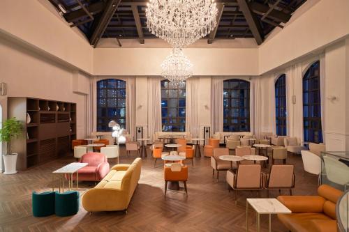 a lobby with tables and chairs and a chandelier at Space and Mood in Busan