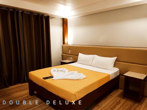 a hotel room with a bed with towels on it at Hotel Mercante in Vigan