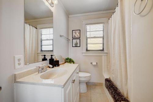 a bathroom with a sink and a toilet and a mirror at Cozy 1-bd oasis Downtown Lake Worth, 5 Star Amenities in Lake Worth