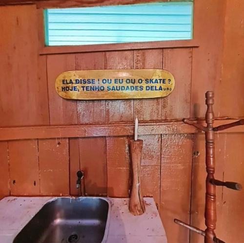 a bathroom with a sink and a sign on the wall at Pousada Amazônia Encantada in Iranduba