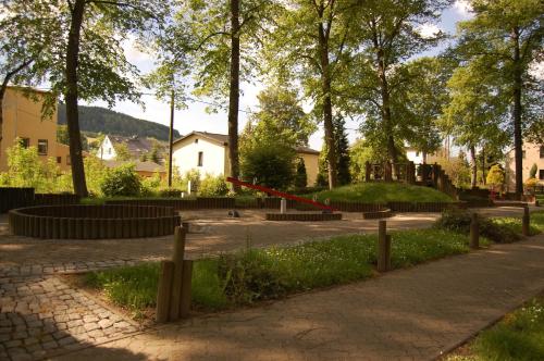 a park with trees and a red line in the grass at Landgasthof "Am Park" in Crottendorf