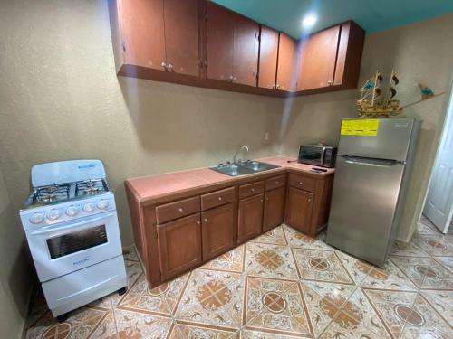 a kitchen with a sink and a stove and refrigerator at Forest View Apartment in Six Huts