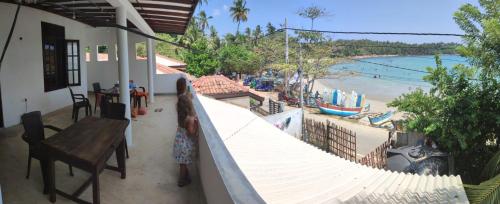 a balcony of a house with a view of a beach at Sea Port Hiriketiya in Hiriketiya