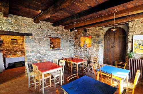 a restaurant with tables and chairs and a stone wall at Casa Vacanze Le Muse Sillico in Pieve Fosciana