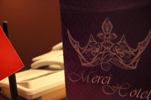 a purple sign with a crown on top of a toilet at Merci Hotel Erbil in Erbil